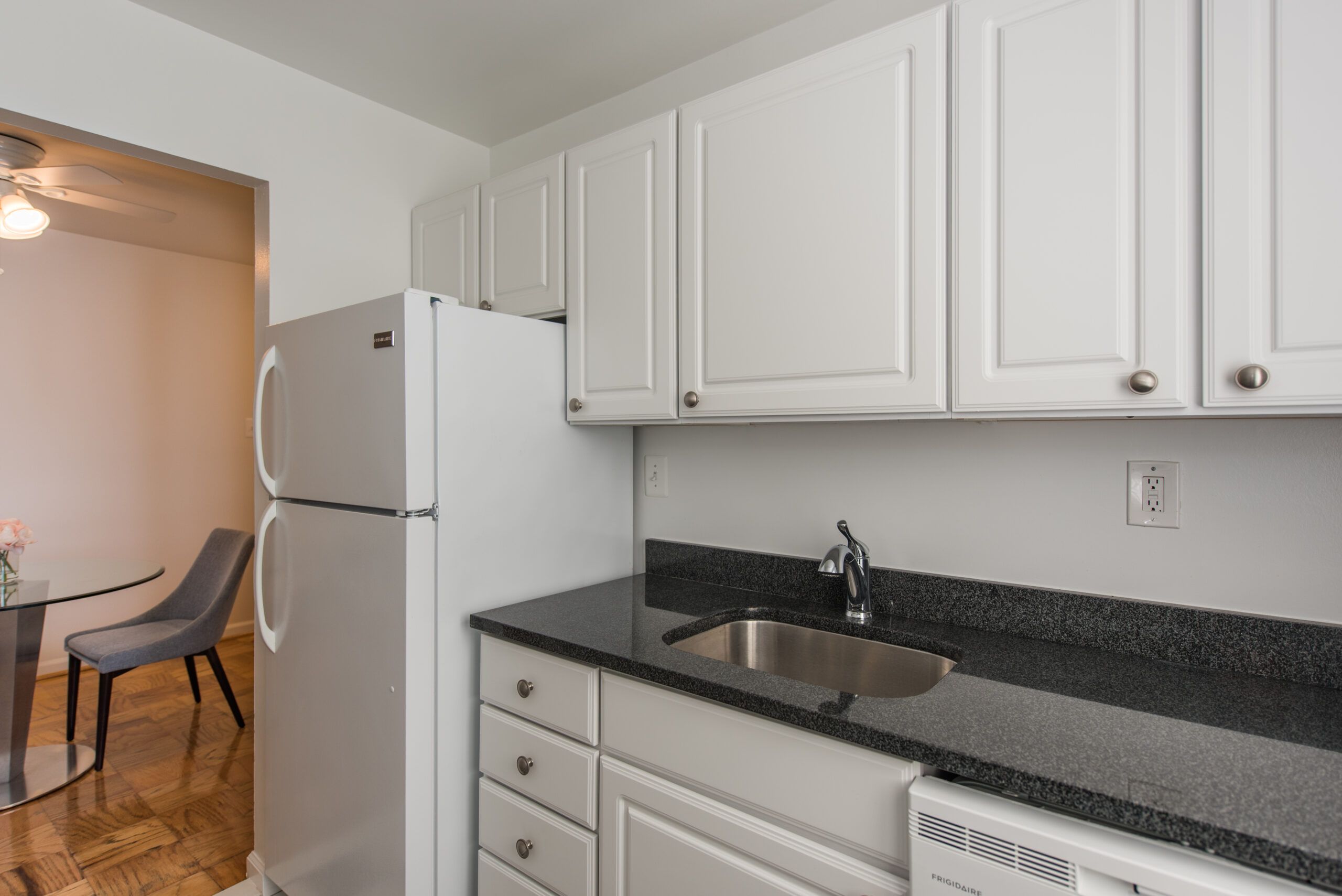 Mason Avenue kitchen with white cabinet tops, black counters and white appliances